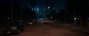 Movie still from “Day Shift” (2022), directed by J.J. Perry – A car driving down a street at night; Extreme Wide shot, High angle