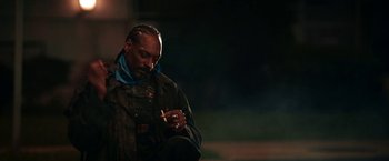 Movie still from “Day Shift” (2022), directed by J.J. Perry – A man in a black jacket is looking at his cell phone; Close Up shot, Over the shoulder angle