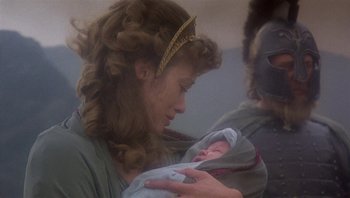 Movie still from “Clash of the Titans” (1981), directed by Desmond Davis – A woman holding a baby in her arms; Close Up shot, Over the shoulder angle
