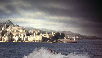 Movie still from “Clash of the Titans” (1981), directed by Desmond Davis – A man riding a surfboard on top of a body of water; Extreme Wide shot, High angle
