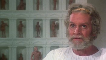 Movie still from “Clash of the Titans” (1981), directed by Desmond Davis – An old man with a beard standing in front of statues; Close Up shot, Low angle