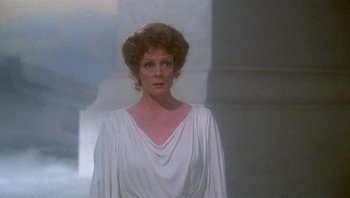 Movie still from “Clash of the Titans” (1981), directed by Desmond Davis – A woman in a white dress standing in front of a wall; Medium shot, Over the shoulder angle