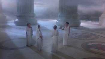 Movie still from “Clash of the Titans” (1981), directed by Desmond Davis – A group of women dressed in white standing in front of pillars; Extreme Wide shot, High angle