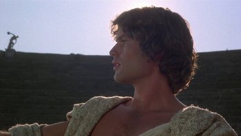 Movie still from “Clash of the Titans” (1981), directed by Desmond Davis – A man with long brown hair wearing a white shirt; Close Up shot, Low angle