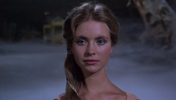 Movie still from “Clash of the Titans” (1981), directed by Desmond Davis – A young woman with long brown hair and blue eyes looking at the camera; Close Up shot, Low angle
