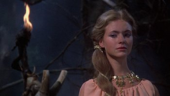 Movie still from “Clash of the Titans” (1981), directed by Desmond Davis – A woman with long blonde hair wearing a pink dress; Close Up shot, Low angle