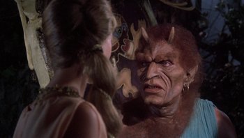 Movie still from “Clash of the Titans” (1981), directed by Desmond Davis – A woman standing in front of a large demon face; Close Up shot, Over the shoulder angle