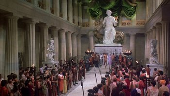Movie still from “Clash of the Titans” (1981), directed by Desmond Davis – A large crowd of people gathered around a statue of a woman; Extreme Wide shot, High angle