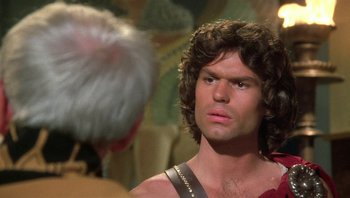 Movie still from “Clash of the Titans” (1981), directed by Desmond Davis – A person with a beard looking at another person; Close Up shot, Over the shoulder angle