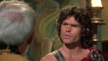 Movie still from “Clash of the Titans” (1981), directed by Desmond Davis – A person with a beard looking at another person; Close Up shot, Over the shoulder angle
