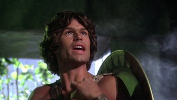 Movie still from “Clash of the Titans” (1981), directed by Desmond Davis – A person holding a green object; Close Up shot, Low angle