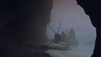 Movie still from “Clash of the Titans” (1981), directed by Desmond Davis – A group of people sitting on top of a boat in the water; Extreme Wide shot, Low angle