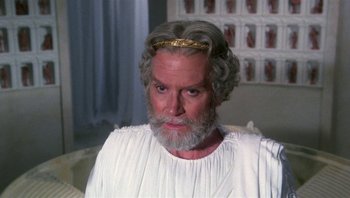 Movie still from “Clash of the Titans” (1981), directed by Desmond Davis – An old man with a beard and a gold crown; Close Up shot, High angle
