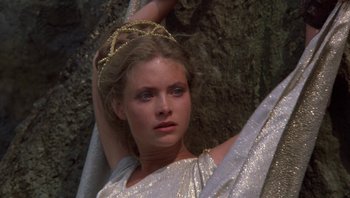 Movie still from “Clash of the Titans” (1981), directed by Desmond Davis – A beautiful woman wearing a silver dress and a gold crown; Close Up shot, High angle
