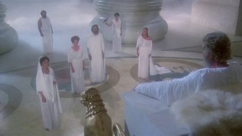 Movie still from “Clash of the Titans” (1981), directed by Desmond Davis – A group of people dressed in white standing in a circle; Wide shot, High angle