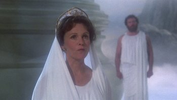 Movie still from “Clash of the Titans” (1981), directed by Desmond Davis – A woman in a white dress and a man in a beard; Medium shot, Over the shoulder angle