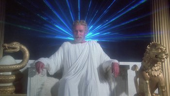 Movie still from “Clash of the Titans” (1981), directed by Desmond Davis – An old man sitting on a chair in front of a blue light; Medium shot, Low angle