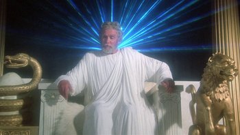 Movie still from “Clash of the Titans” (1981), directed by Desmond Davis – An old man dressed in white sitting on top of a bench; Medium shot, Overhead angle
