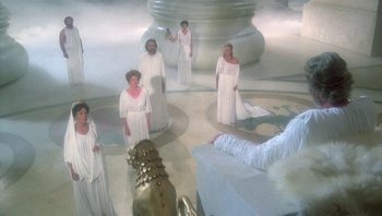 Movie still from “Clash of the Titans” (1981), directed by Desmond Davis – A group of people dressed in white standing in a circle; Wide shot, High angle