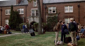 Movie still from “Class” (1983), directed by Lewis John Carlino – A group of people standing in front of a brick building; Wide shot, High angle