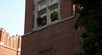 Movie still from “Class” (1983), directed by Lewis John Carlino – A group of young people standing on a window ledge; Wide shot, Low angle
