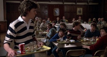 Movie still from “Class” (1983), directed by Lewis John Carlino – A group of people sitting at tables with trays of food; Medium shot, Over the shoulder angle