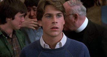 Movie still from “Class” (1983), directed by Lewis John Carlino – A young man in a blue sweater looking at the camera; Close Up shot, Over the shoulder angle