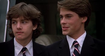 Movie still from “Class” (1983), directed by Lewis John Carlino – Two young men in suits and ties standing next to each other; Close Up shot, High angle