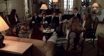 Movie still from “Class” (1983), directed by Lewis John Carlino – A group of people sitting around a living room drinking coffee; Wide shot, High angle