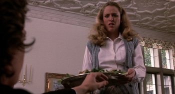 Movie still from “Class” (1983), directed by Lewis John Carlino – A woman holding a tray of food in front of a man; Medium shot, Low angle