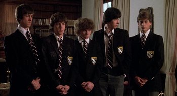 Movie still from “Class” (1983), directed by Lewis John Carlino – A group of young men standing next to each other wearing ties; Medium shot, Low angle
