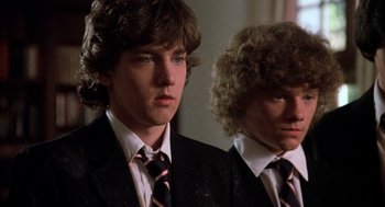 Movie still from “Class” (1983), directed by Lewis John Carlino – Two young men in suits and ties standing next to each other; Close Up shot, Low angle