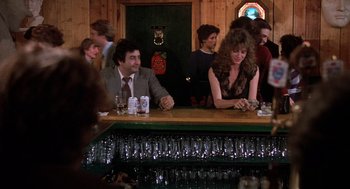 Movie still from “Class” (1983), directed by Lewis John Carlino – A group of people sitting at a bar with drinks; Medium shot, Over the shoulder angle