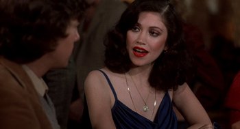 Movie still from “Class” (1983), directed by Lewis John Carlino – A woman with red lipstick is sitting in front of a group of people; Close Up shot, Over the shoulder angle