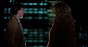 Movie still from “Class” (1983), directed by Lewis John Carlino – A man and a woman standing next to each other in front of a building; Medium shot, Low angle