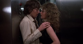 Movie still from “Class” (1983), directed by Lewis John Carlino – A man and a woman kissing in front of an elevator; Medium shot, Low angle