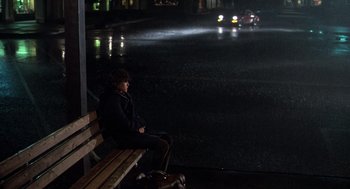 Movie still from “Class” (1983), directed by Lewis John Carlino – A person sitting on a bench in the dark; Wide shot, High angle