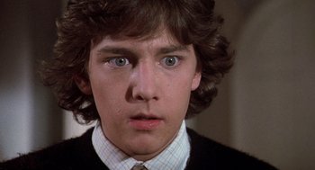 Movie still from “Class” (1983), directed by Lewis John Carlino – A person wearing a suit and tie; Close Up shot, Low angle