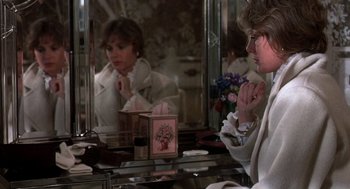 Movie still from “Class” (1983), directed by Lewis John Carlino – A woman sitting in front of a mirror looking at herself in the mirror; Medium shot, Over the shoulder angle