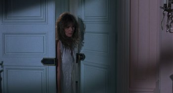 Movie still from “Class” (1983), directed by Lewis John Carlino – A woman standing in front of a white door; Medium shot, Over the shoulder angle