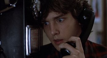 Movie still from “Class” (1983), directed by Lewis John Carlino – A young man is talking on a phone; Close Up shot, Low angle