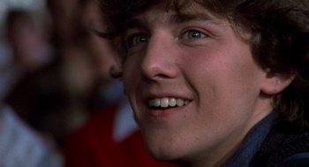 Movie still from “Class” (1983), directed by Lewis John Carlino – A person smiling; Close Up shot, Low angle