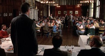 Movie still from “Class” (1983), directed by Lewis John Carlino – A group of people sitting at tables in a room; Wide shot, Over the shoulder angle