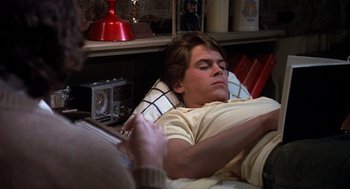 Movie still from “Class” (1983), directed by Lewis John Carlino – A man laying in a bed with his head on a pillow; Medium shot, High angle