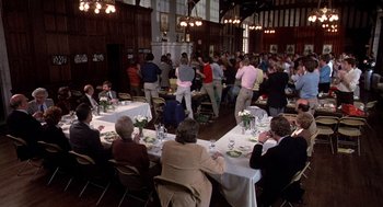 Movie still from “Class” (1983), directed by Lewis John Carlino – A group of people sitting at a table in a room; Wide shot, High angle