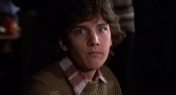 Movie still from “Class” (1983), directed by Lewis John Carlino – A young man in a brown sweater stares into the camera; Close Up shot, Low angle