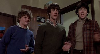 Movie still from “Class” (1983), directed by Lewis John Carlino – A group of young men standing next to each other in a room; Medium shot, Low angle