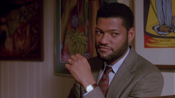 Movie still from “Class Action” (1991), directed by Michael Apted – A man in a suit and tie holding a watch; Close Up shot, Low angle