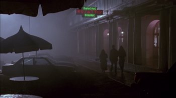 Movie still from “Class Action” (1991), directed by Michael Apted – A group of people walking down a street at night; Wide shot, High angle