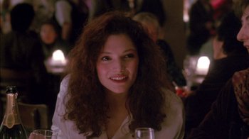 Movie still from “Class Action” (1991), directed by Michael Apted – A woman sitting at a table with a glass of wine; Close Up shot, Over the shoulder angle